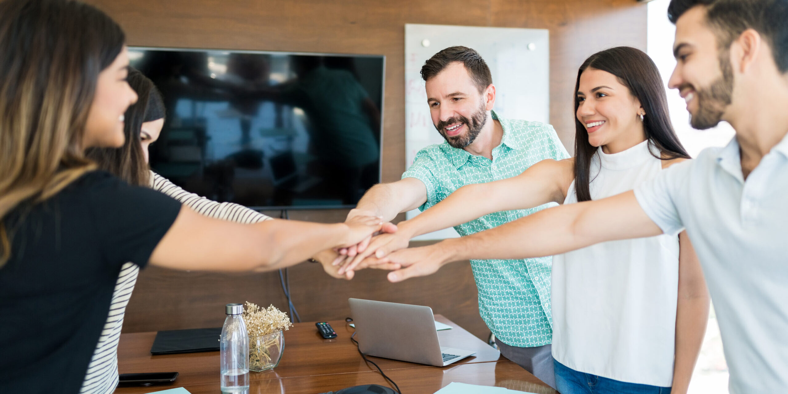 Business Team With Hands Stacked Together In Meeting