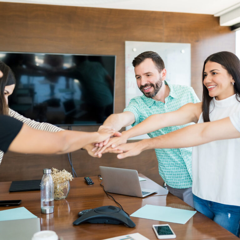 Business Team With Hands Stacked Together In Meeting
